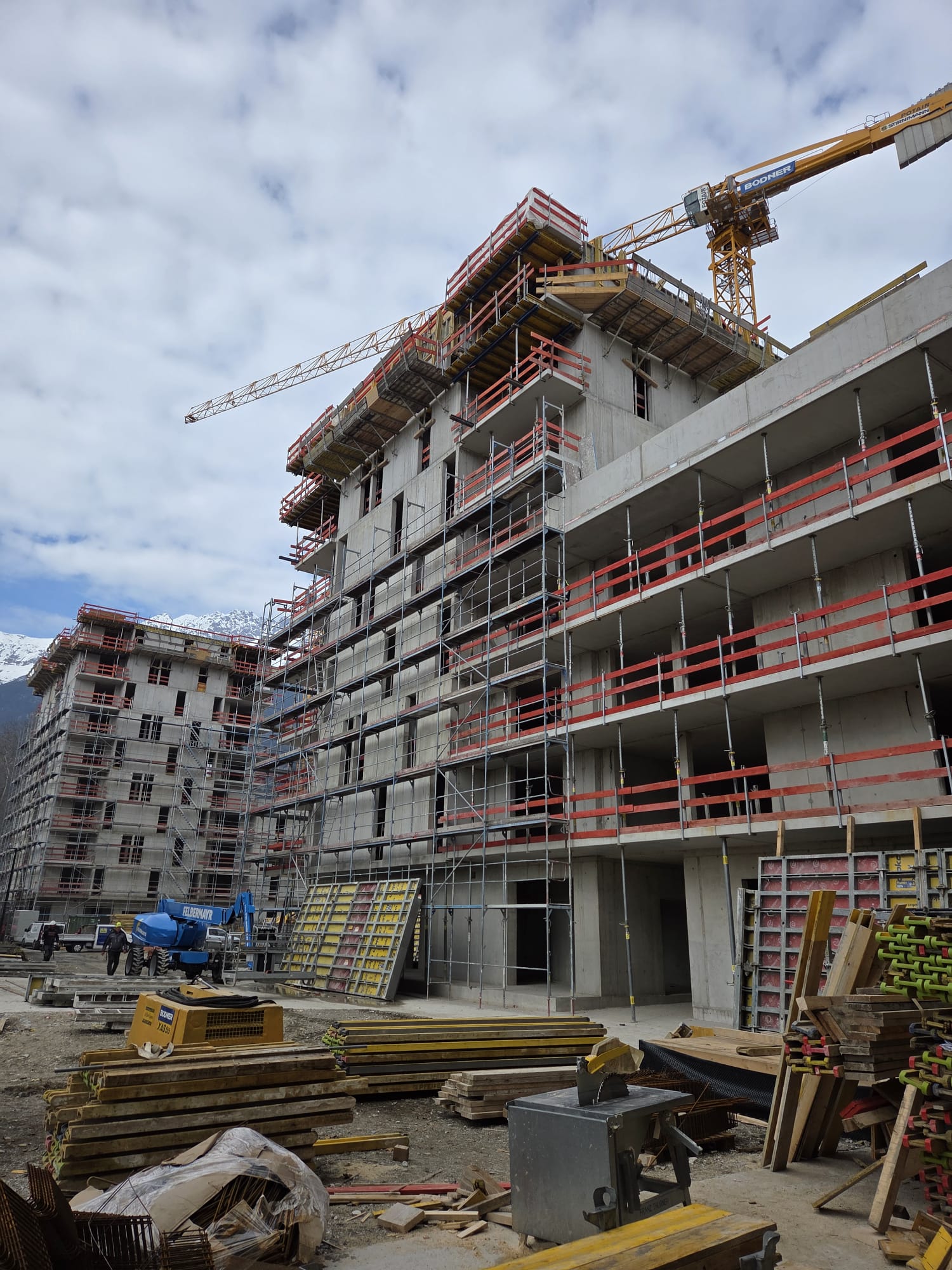 Mehrgeschossiger Stahlbetonrohbau mit Gerüst und Kran in Innsbruck